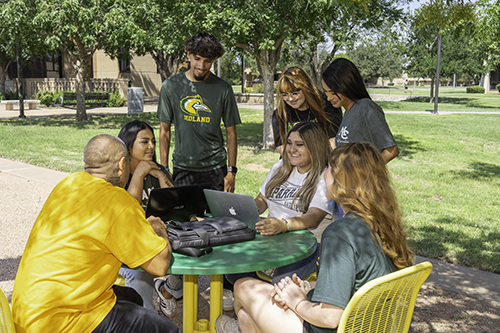Students sitting at a table outside