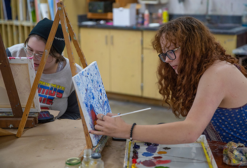 Art students painting in classroom