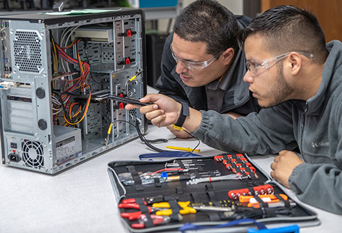 Information Technology students studying the interior of a computer