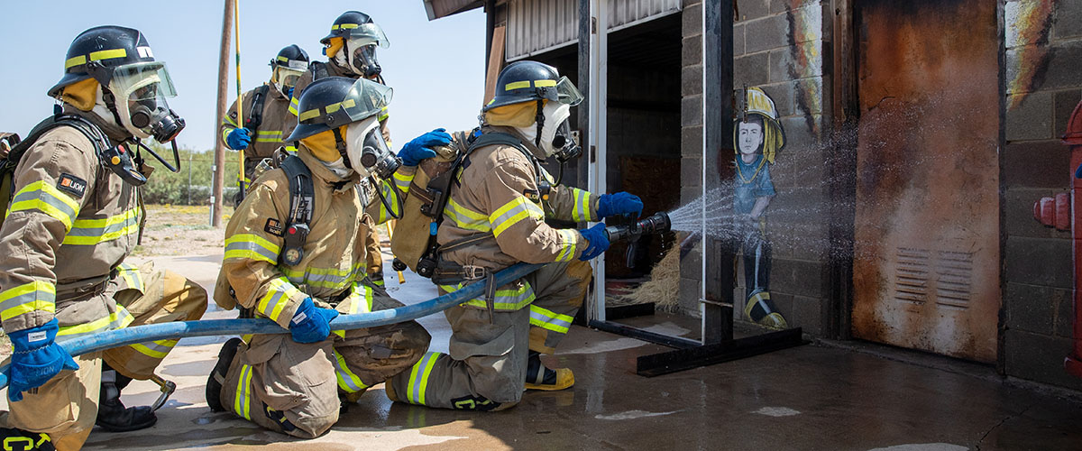 Student Firemen hosing building