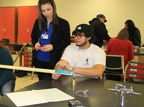 Physics student and instructor in lab experiment