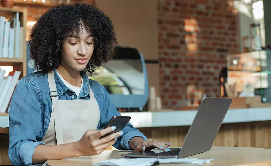 Young person looking at phone learning to Budget for Beginners