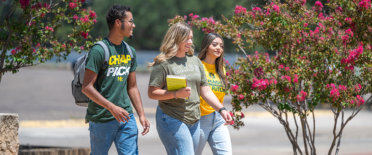 Three Midland College students in Midland College shirts walking together on campus
