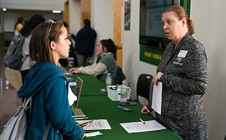 Student and staff member at career fair